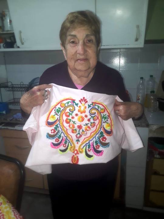 mujer mostrando una tela bordada