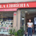 Persona en la puerta de la librería con un cuaderno.