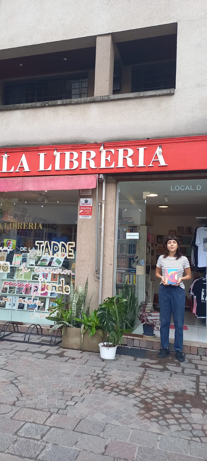 Persona en la puerta de la librería con un cuaderno.