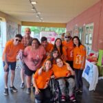 Grupo de personas de la Fundación por Igual Más, con las remeras naranjas institucionales posando para la fotografía.
