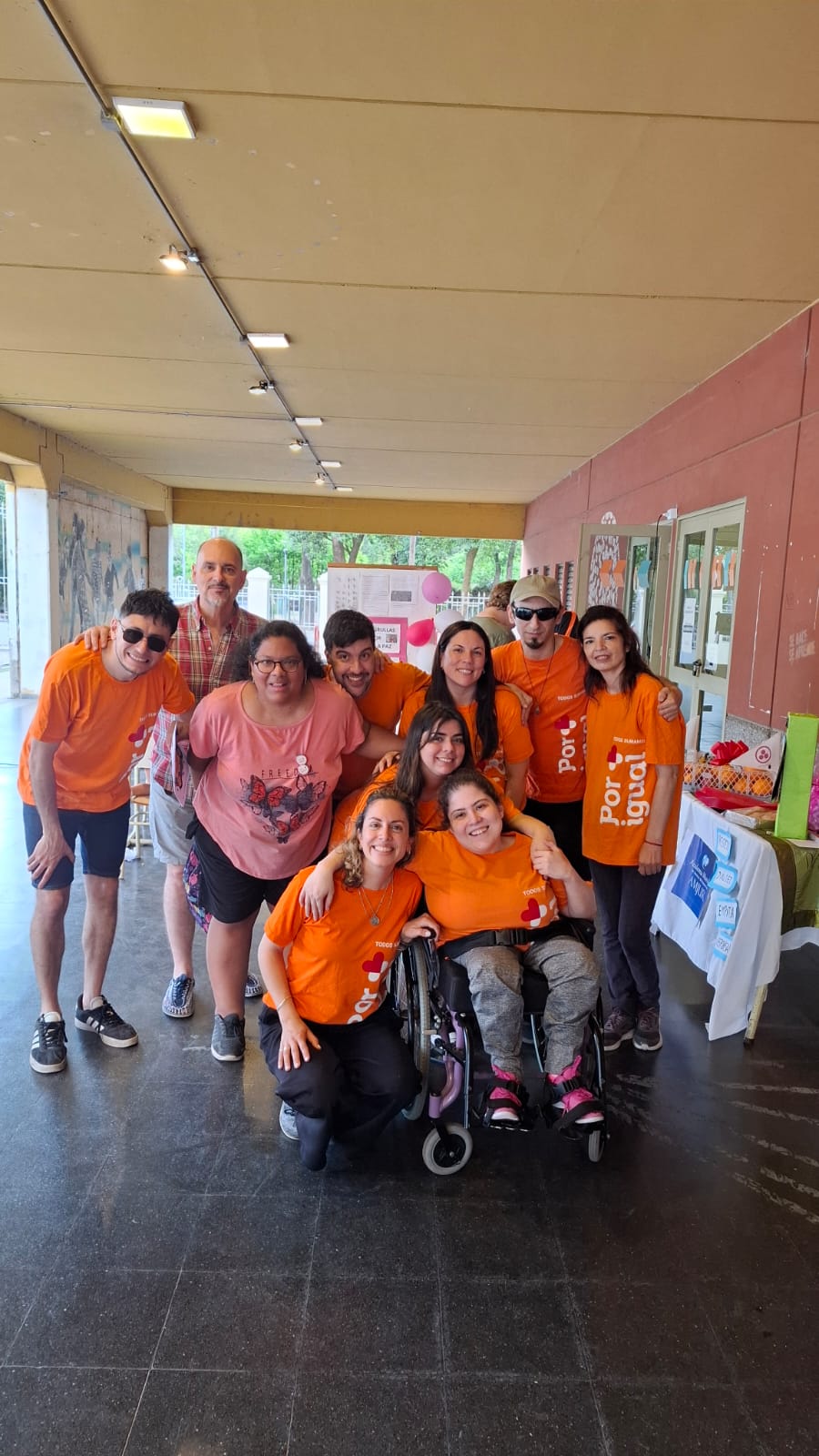 Grupo de personas de la Fundación por Igual Más, con las remeras naranjas institucionales posando para la fotografía.