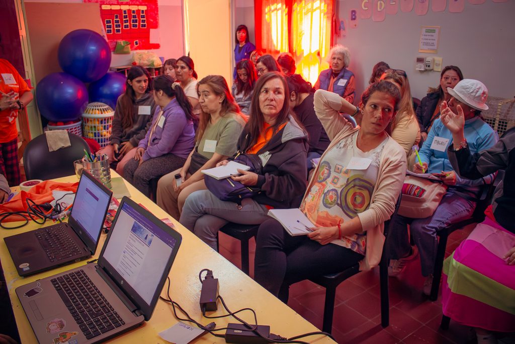 mujeres en un mesa y  un voluntario de la fundación 