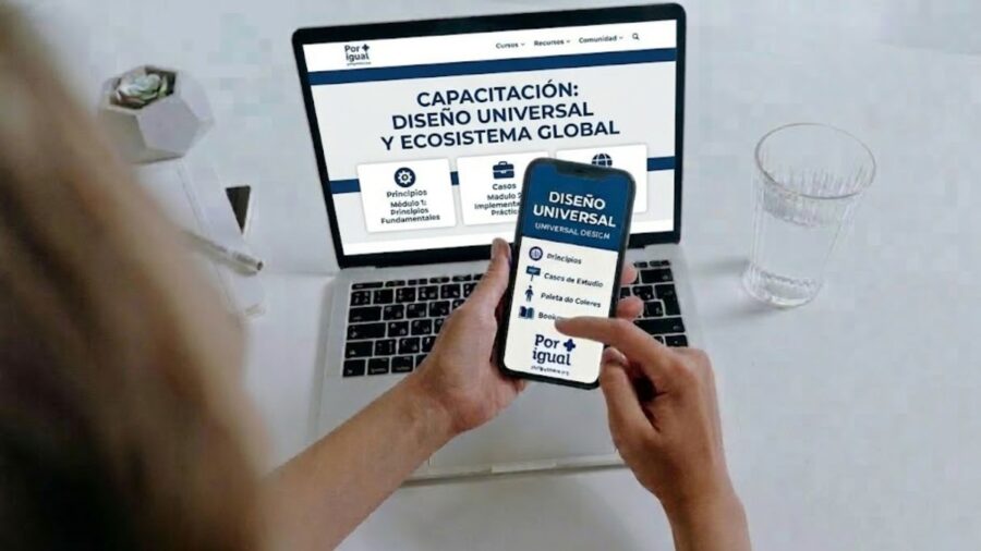 Una persona utiliza una laptop y un celular que muestran el portal de capacitación de "Por igual +". En las pantallas se lee "Diseño Universal y Ecosistema Global" sobre un fondo blanco y azul, junto a iconos de accesibilidad y el logo de la organización.