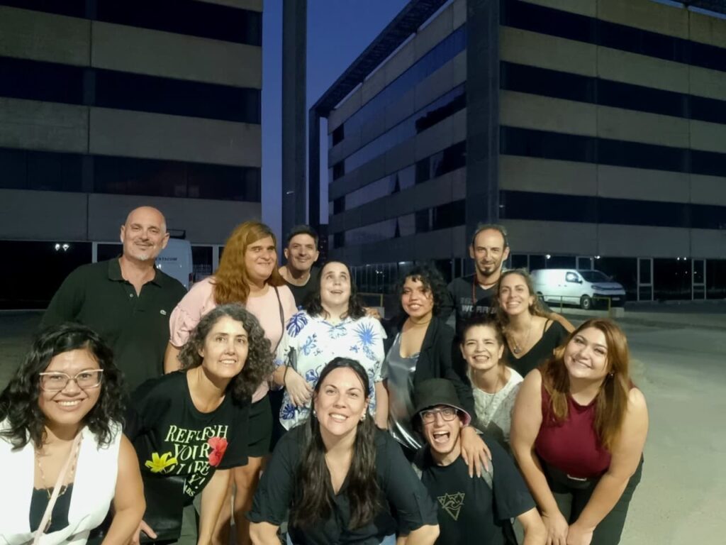 el quipo de producción del corto, 12 personas  al fondo un edificio.