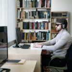 una persona ciega con articulares frente a una computadora