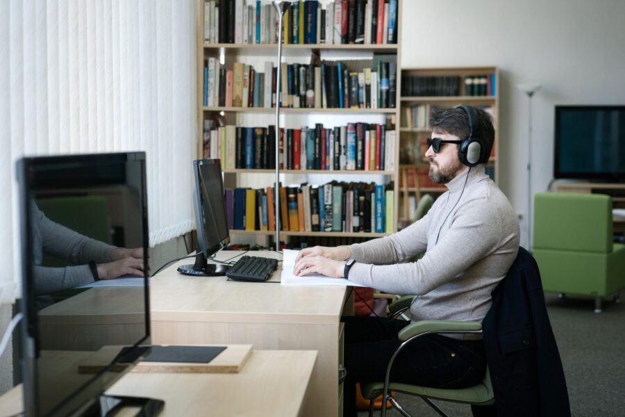 pexels-mikhail-nilov-6981101 una persona ciega con articulares frente a una computadora