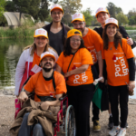 grupo de voluntarios con las remeras entre ellos una en silla en ruedas
